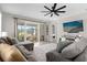Cozy living room offering a plush sectional, ceiling fan, backyard views and access to the screened-in lanai at 284 White Heron Way, St Cloud, FL 34772