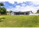 Expansive backyard featuring a large, screened-in patio, lush green grass, and a privacy fence at 2903 Clear Way, Orlando, FL 32805