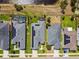This aerial view showcases solar panels, a screened-in pool, and houses near a scenic marshland at 2941 Marlberry Ln, Clermont, FL 34714