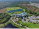 Aerial view showing a community center, pool, playground, lake, green space, and parking at 2941 Marlberry Ln, Clermont, FL 34714