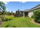 Grassy backyard features a screened-in lanai, mature trees, and beautiful landscaping for serene outdoor living at 2941 Marlberry Ln, Clermont, FL 34714