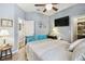 Comfortable bedroom with ceiling fan, mounted TV, and ensuite bathroom access at 2941 Marlberry Ln, Clermont, FL 34714