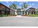 Community entrance with palm trees, flowers and modern building architecture at 2941 Marlberry Ln, Clermont, FL 34714