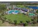 A wide aerial shot showcases the community pool, splash pad, recreation center, and playground at 2941 Marlberry Ln, Clermont, FL 34714