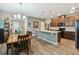 Open kitchen and dining area featuring granite counters, stainless appliances, and wood floors at 2941 Marlberry Ln, Clermont, FL 34714