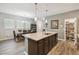 Open kitchen and dining area featuring granite counters, stainless appliances, and wood floors at 2941 Marlberry Ln, Clermont, FL 34714