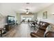 Spacious living room with hardwood floors, ceiling fan, and view to screened patio at 2941 Marlberry Ln, Clermont, FL 34714