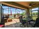 Screened patio with outdoor seating, ceiling fan, grill, and views of the serene lake and manicured landscaping at 2941 Marlberry Ln, Clermont, FL 34714