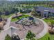 View of a playground with slides and climbing equipment surrounded by sidewalks and manicured green space at 2941 Marlberry Ln, Clermont, FL 34714