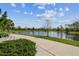 Scenic view of the community pond with walking path and mature trees at 2941 Marlberry Ln, Clermont, FL 34714