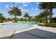 Scenic community pool with surrounding palm trees, lounge chairs, and clear water, creating a relaxing environment for residents at 2941 Marlberry Ln, Clermont, FL 34714
