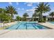 Large community pool with marked lanes, surrounded by palm trees and lounge chairs, offering a relaxing and refreshing experience at 2941 Marlberry Ln, Clermont, FL 34714