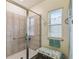 Bathroom shower with glass door, tile surround, bench and handrails at 2941 Marlberry Ln, Clermont, FL 34714