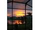 Enclosed lanai showcasing colorful sunset views over the water feature at 2941 Marlberry Ln, Clermont, FL 34714