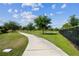 Community walking path with lush green space, mature trees and landscaping at 2941 Marlberry Ln, Clermont, FL 34714