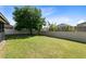 This fenced-in backyard features a grassy lawn, mature landscaping, and a screened-in porch at 30245 Cheval St, Mount Dora, FL 32757