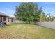 This fenced-in backyard features a grassy lawn and mature landscaping at 30245 Cheval St, Mount Dora, FL 32757