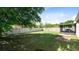 This fenced-in backyard features a grassy lawn, mature landscaping, and a screened-in porch at 30245 Cheval St, Mount Dora, FL 32757