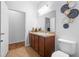 Bathroom showcases a single sink vanity with dark wood cabinets, decorative wall art, and stylish tile flooring for a refined look at 30245 Cheval St, Mount Dora, FL 32757