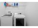 A clean laundry room features a full-sized washer and dryer set and overhead wire shelving at 30245 Cheval St, Mount Dora, FL 32757