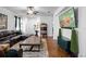 Bright living room with a plush sectional, wood floors, ceiling fan, and open layout to the entryway at 30245 Cheval St, Mount Dora, FL 32757