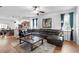 Open-concept living room showcasing a large sectional sofa, wood floors, and seamless flow to the kitchen at 30245 Cheval St, Mount Dora, FL 32757