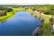 Aerial view of a neighborhood pond with walking path and lush landscaping at 30245 Cheval St, Mount Dora, FL 32757