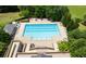 Aerial view of a large community pool with sundeck and lounge chairs and lush landscaping at 30245 Cheval St, Mount Dora, FL 32757