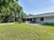 Backyard featuring lush green grass, a cozy fire pit, outdoor patio, and mature landscaping at 3104 Lime Tree Dr, Edgewater, FL 32141