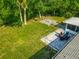 Aerial view of backyard with brick patio, outdoor dining set, fire pit, screened in porch, and mature trees at 3104 Lime Tree Dr, Edgewater, FL 32141