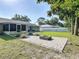 Relaxing backyard with patio, dining set, screened lanai, fire pit, lush lawn, and mature landscaping at 3104 Lime Tree Dr, Edgewater, FL 32141