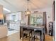 Bright dining area featuring a modern table set, wood-look floors, and seamless transition to the kitchen at 3104 Lime Tree Dr, Edgewater, FL 32141