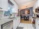 Stylish kitchen showcasing white cabinets, granite countertops, stainless steel appliances, and view of the dining area at 3104 Lime Tree Dr, Edgewater, FL 32141