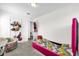 Bedroom featuring bright pink bed, gray carpeting, and playful decor at 3206 Water Sprite St, Orlando, FL 32808