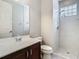 Bright bathroom featuring a walk-in shower with glass blocks and a wood vanity with a large mirror at 3213 Kentshire Blvd, Ocoee, FL 34761