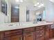 Bathroom with dual sinks, dark wood cabinets, and a large mirror at 3213 Kentshire Blvd, Ocoee, FL 34761