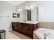 Bathroom featuring dual sinks, dark wood cabinetry, and separate tub and shower at 3213 Kentshire Blvd, Ocoee, FL 34761