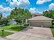 Charming home with a well-manicured lawn, mature landscaping, and three-car garage at 3213 Kentshire Blvd, Ocoee, FL 34761