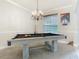 Bright game room with a pool table, stylish chandelier, and large window at 3213 Kentshire Blvd, Ocoee, FL 34761