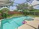 Sparkling screened-in pool with lush landscaping creates a private backyard oasis at 3213 Kentshire Blvd, Ocoee, FL 34761