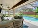 Screened-in pool area with comfortable seating, a TV, and view of the backyard, perfect for relaxing at 3213 Kentshire Blvd, Ocoee, FL 34761