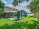 Beautiful screened-in pool area surrounded by lush green lawn and mature trees at 3213 Kentshire Blvd, Ocoee, FL 34761
