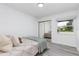 Bright bedroom with gray wood-look floors, neutral decor, and ample natural light at 322 Shadow Oak Dr, Casselberry, FL 32707
