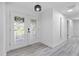 Bright entryway featuring elegant glass double doors and light gray wood-look floors flowing into a hallway at 322 Shadow Oak Dr, Casselberry, FL 32707