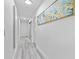 Bright hallway featuring light gray wood-look floors and a painting on the wall at 322 Shadow Oak Dr, Casselberry, FL 32707