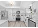 Modern kitchen featuring stainless steel appliances, white cabinets, quartz countertops, and wood-look floors at 322 Shadow Oak Dr, Casselberry, FL 32707
