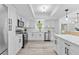 Modern kitchen featuring stainless steel appliances, white cabinets, quartz countertops, and wood-look floors at 322 Shadow Oak Dr, Casselberry, FL 32707