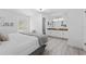 Spacious main bedroom leading into ensuite bath with double vanity, featuring wood-look flooring and a door to backyard at 322 Shadow Oak Dr, Casselberry, FL 32707