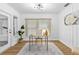 Bright home office with a large window, plank accent wall, wood floors, and an exterior door at 322 Shadow Oak Dr, Casselberry, FL 32707
