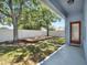 Landscaped backyard with a wooden deck, white fence, and lush green grass, perfect for outdoor enjoyment at 3259 Alling Ct, Deltona, FL 32725